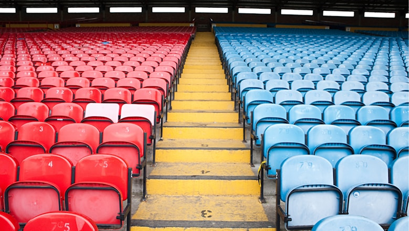 Spectators in a football stadium at night under floodlights