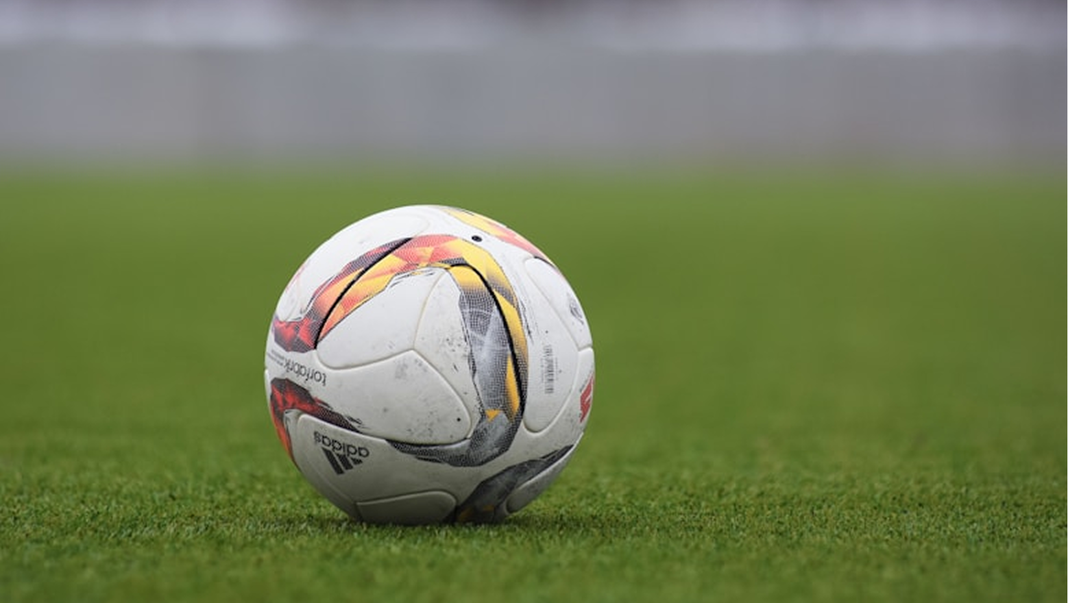 Official match football on pitch grass